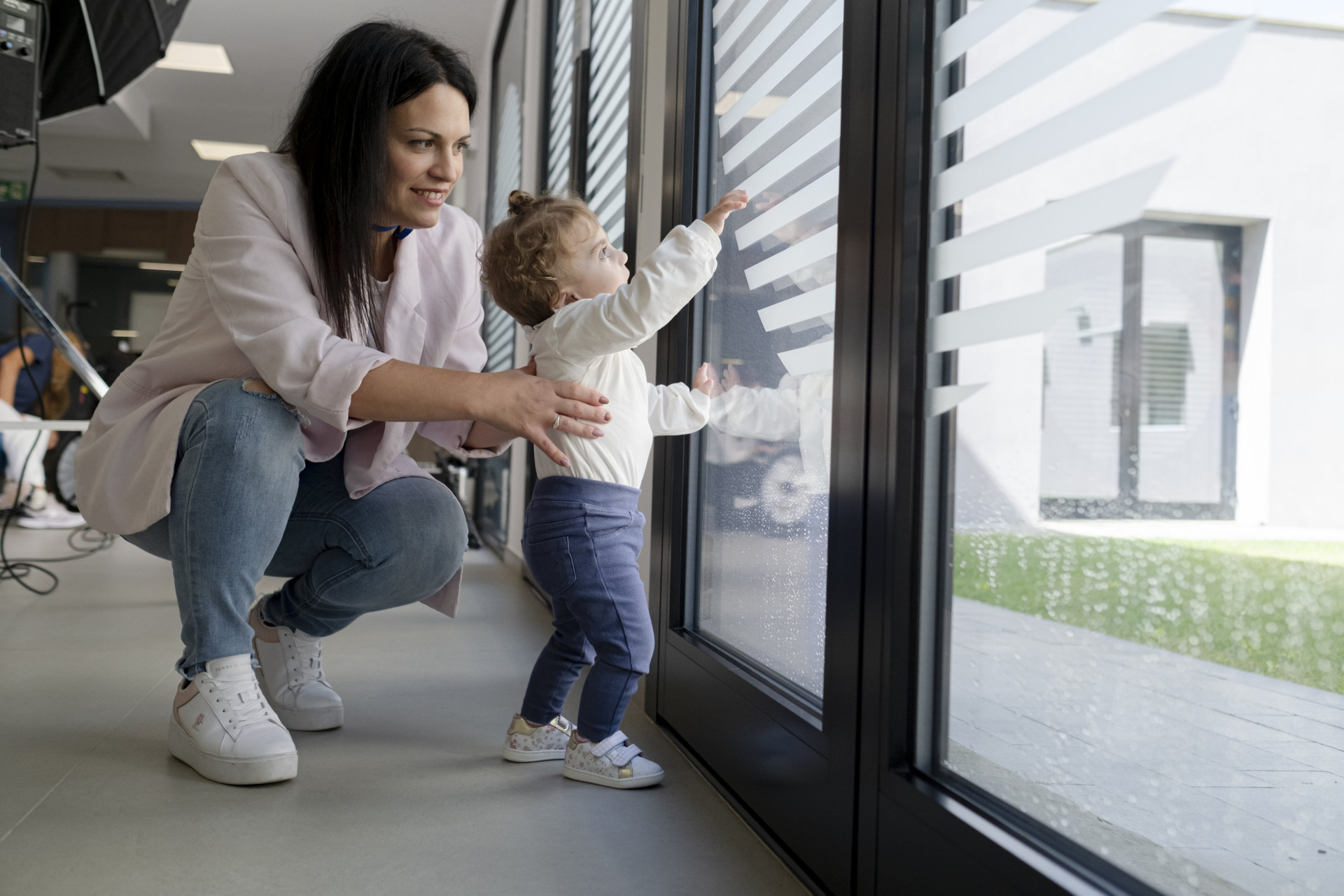 Mamma Agostina e Benedetta che giocano alla finestra della Sala d'Attesa del Centro Nazionale a Osimo