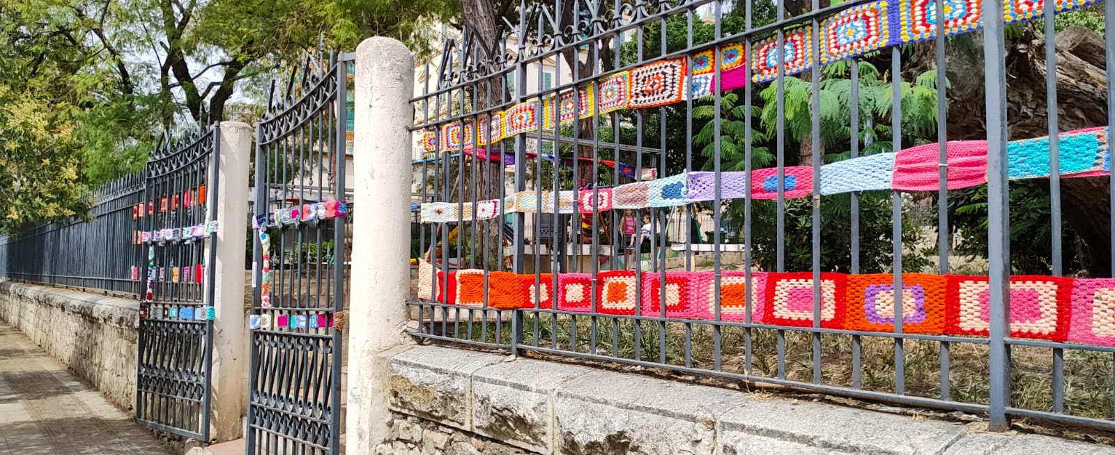 La Lega del Filo d’Oro ha aderito e promosso lo Yarn Bombing. Nell’immagine si vede la recinzione di un giardino decorata con creazioni in maglia colorata.