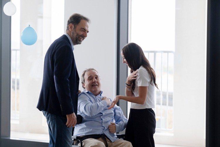 Neri Marcorè tiene la mano sulla spalla di Alberto che a sua volta stringe la mano della sua educatrice