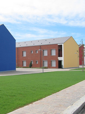 Foto degli adifici residenziali del Centro di Lesmo, visibili le tre facciate distinte dai colori rosso, giallo e blu
