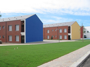 Foto degli adifici residenziali del Centro di Lesmo, visibili le tre facciate distinte dai colori rosso, giallo e blu