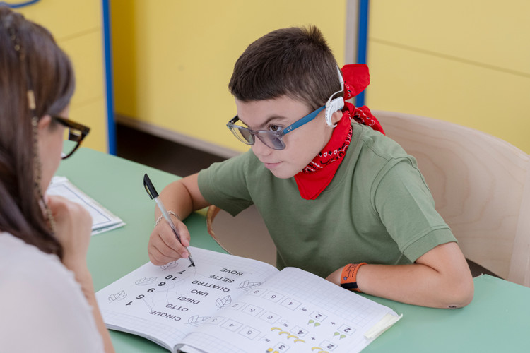 Leonardo con l'educatrice mentre fa i compiti