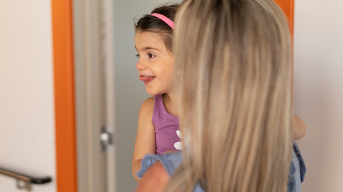 Letizia, bambina sordocieca, in primo piano con la sua educatrice all'interno del nuovo centro nazionale. Letizia ha una buffa espressione sul viso. E' serena