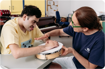 Simone durante la sua ora di musicoterapia, suona il tamburo con la sua insegnate Fiammetta
