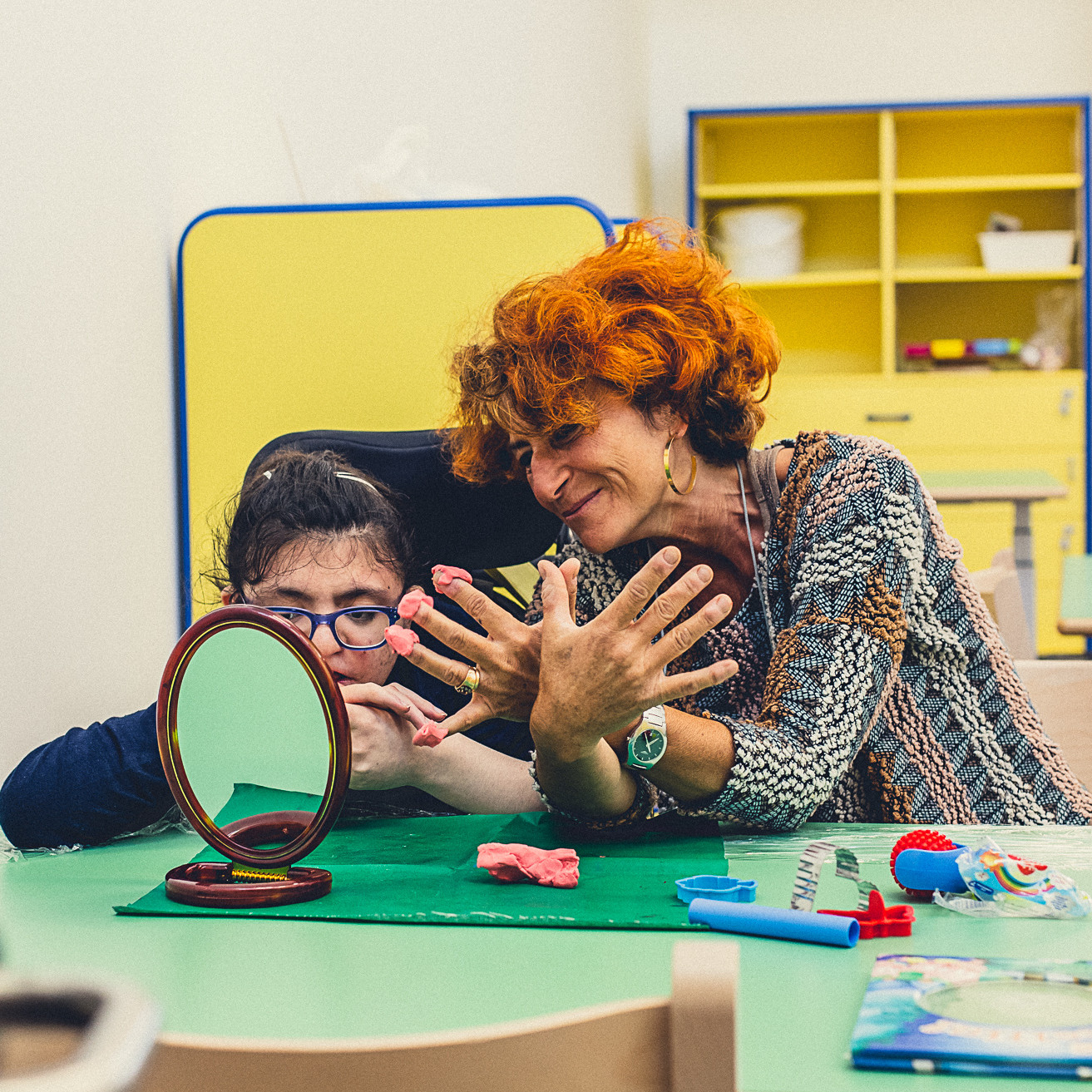 Una piccola utente del Centro di Osimo fa un lavoretto con la plastilina insieme alla sua educatrice