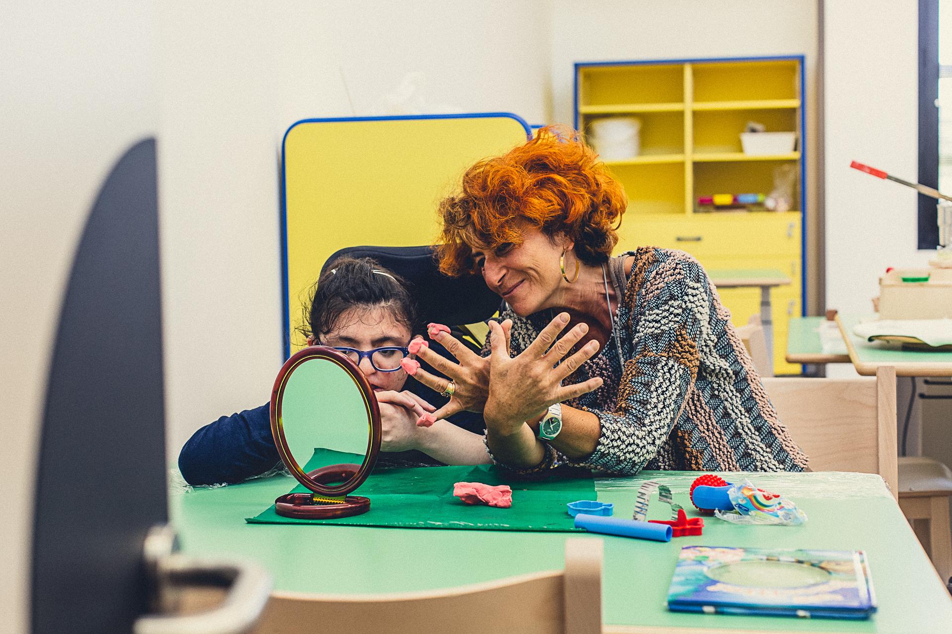 Una piccola utente del Centro di Osimo fa un lavoretto con la plastilina insieme alla sua educatrice