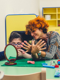 Una piccola utente del Centro di Osimo fa un lavoretto con la plastilina insieme alla sua educatrice