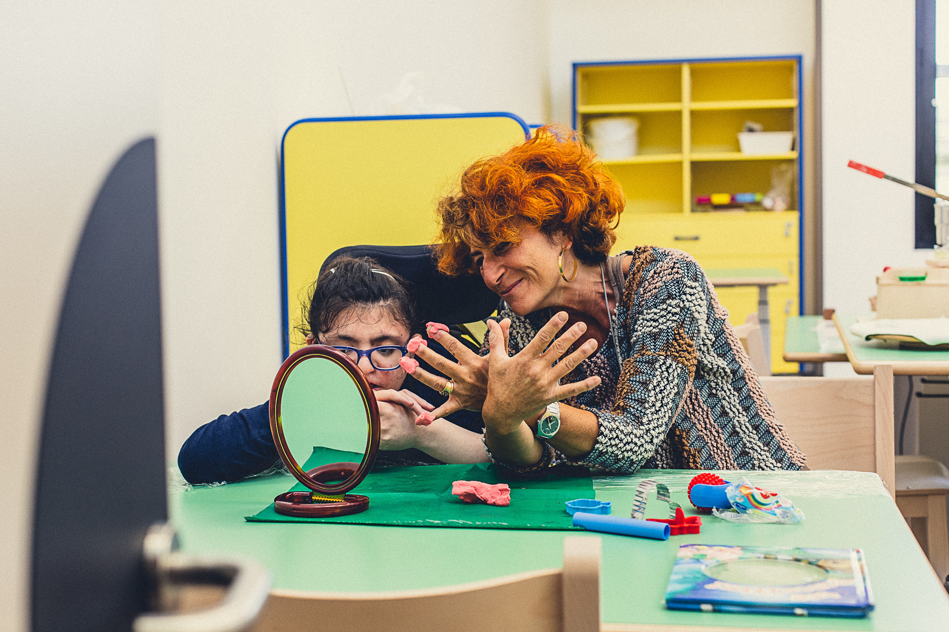 Una piccola utente del Centro di Osimo fa un lavoretto con la plastilina insieme alla sua educatrice