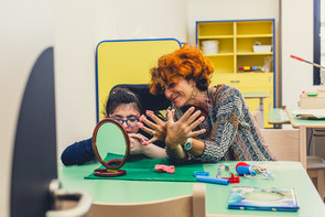 Una piccola utente del Centro di Osimo fa un lavoretto con la plastilina insieme alla sua educatrice