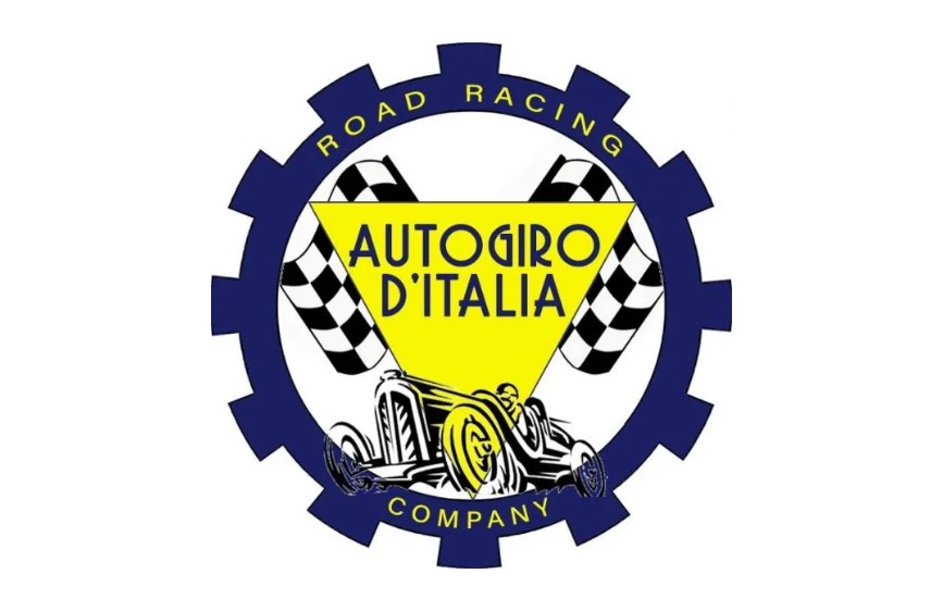 logo della "Autogiro d'Italia Road Racing Company". Il logo è racchiuso in una forma circolare stilizzata che assomiglia a un ingranaggio blu scuro, con il testo "ROAD RACING COMPANY" scritto lungo il bordo superiore e inferiore. Al centro, un triangolo giallo rivolto verso il basso contiene la scritta "AUTOGIRO D'ITALIA" e un'illustrazione in bianco e nero di un'auto da corsa d'epoca. Ai lati del triangolo, due bandiere a scacchi, tipiche delle gare automobilistiche, completano il design.