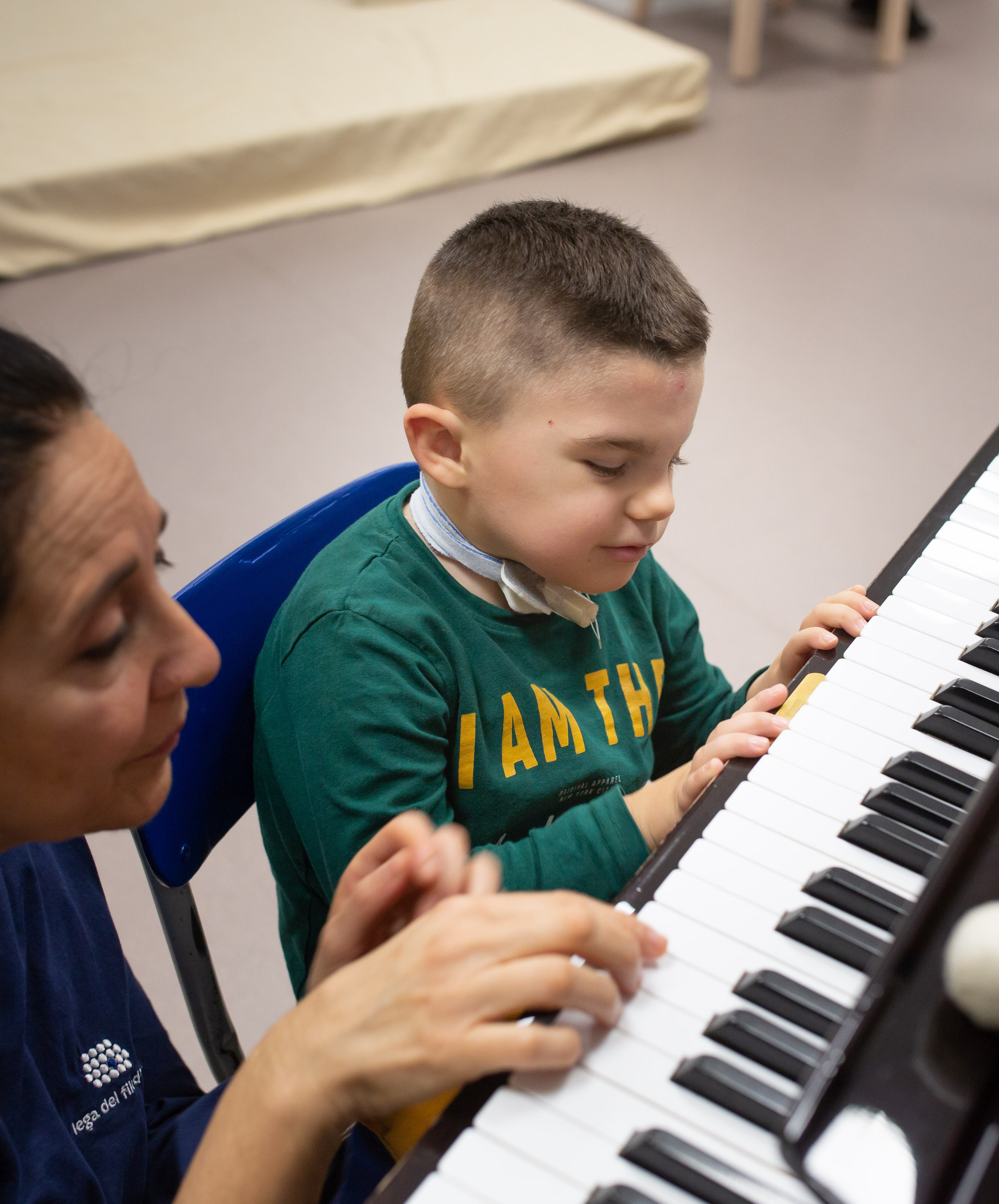 Leonardo, un bambino affetto della sindrome di Charge, suona al pianoforte con Fimmetta, musicoterapista del Centro di Osimo della Lega del Filo d'Oro