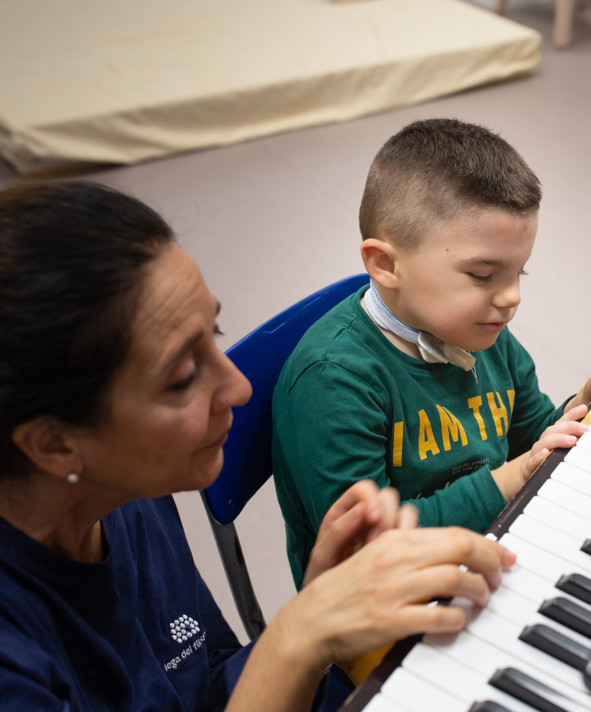 Leonardo, un bambino affetto della sindrome di Charge, suona al pianoforte con Fimmetta, musicoterapista del Centro di Osimo della Lega del Filo d'Oro