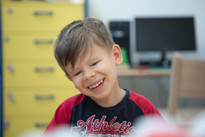 Un utente bambino della Lega del Filo d'Oro sorride in primo piano