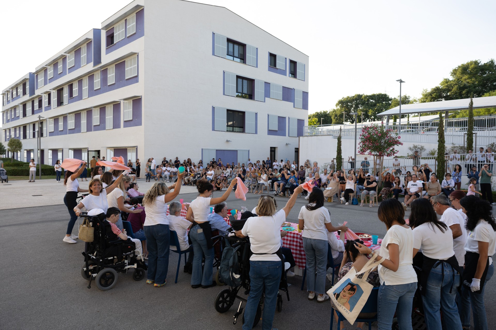 Utenti e operatori, insieme a familiari, volontari ed amici, mentre recitano durante lo spettacolo dell'estate, nel piazzale tra la palazzina azzurra e la palazzina viola
