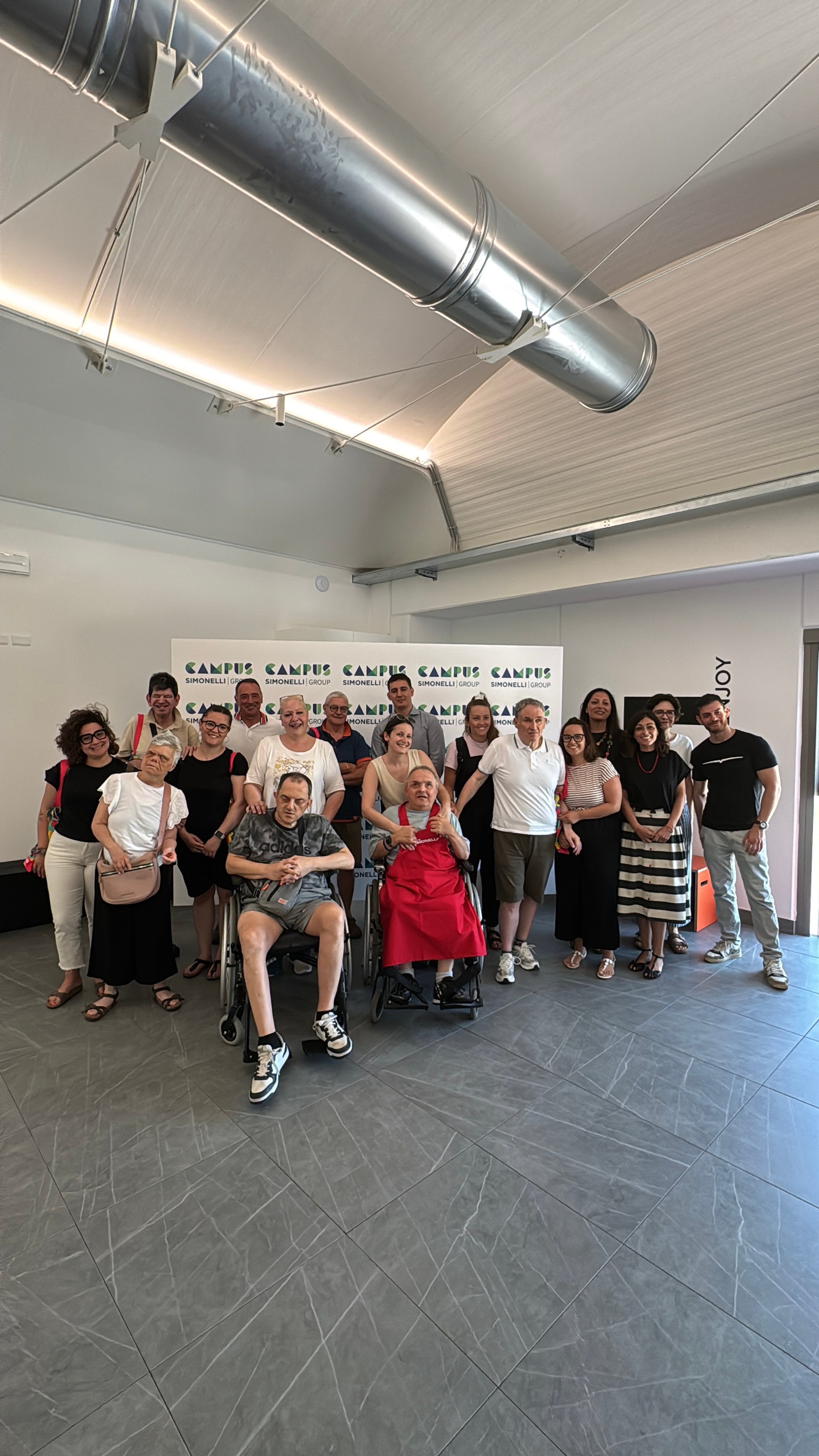 Foto di gruppo di ospiti adulti, educatori e volontari del Centro di Osimo in visita all'azienda Simonelli group per un laboratorio sensoriale sul caffé