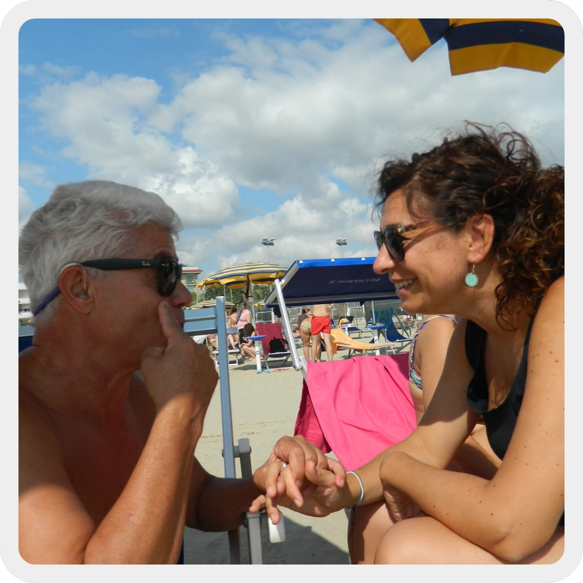 Seduti sui lettini di uno stabilimento balneare durante un soggiorno estivo, un'assistente sociale e un uomo sordocieco di circa 60 anni conversano attraverso la Lis tattile. 