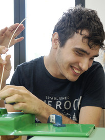 Francesco, all'interno dei laboratori del Centro della Lega del Filo d'Oro, lavora il midollino per costruire dei cestini