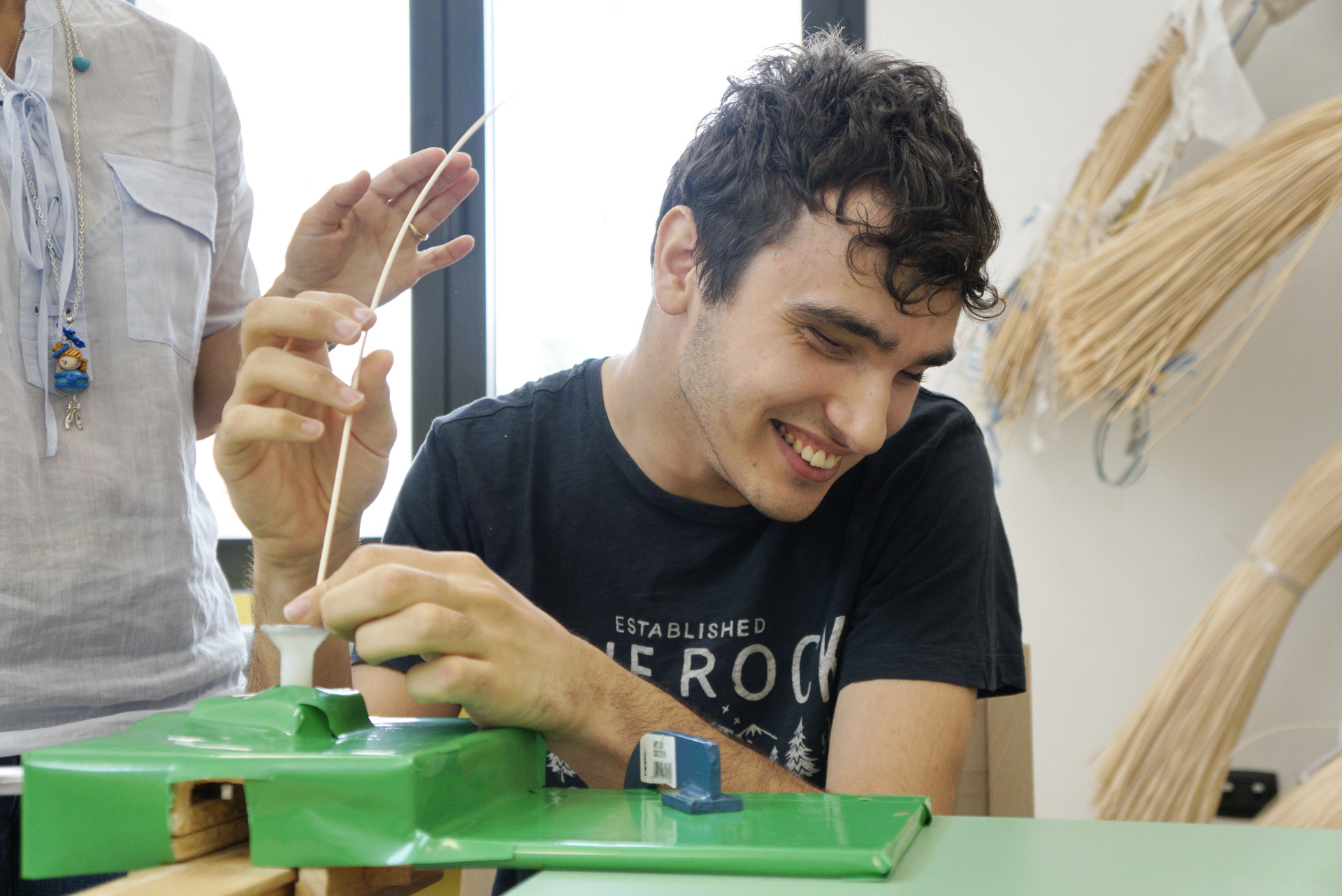Francesco, all'interno dei laboratori del Centro della Lega del Filo d'Oro, lavora il midollino per costruire dei cestini