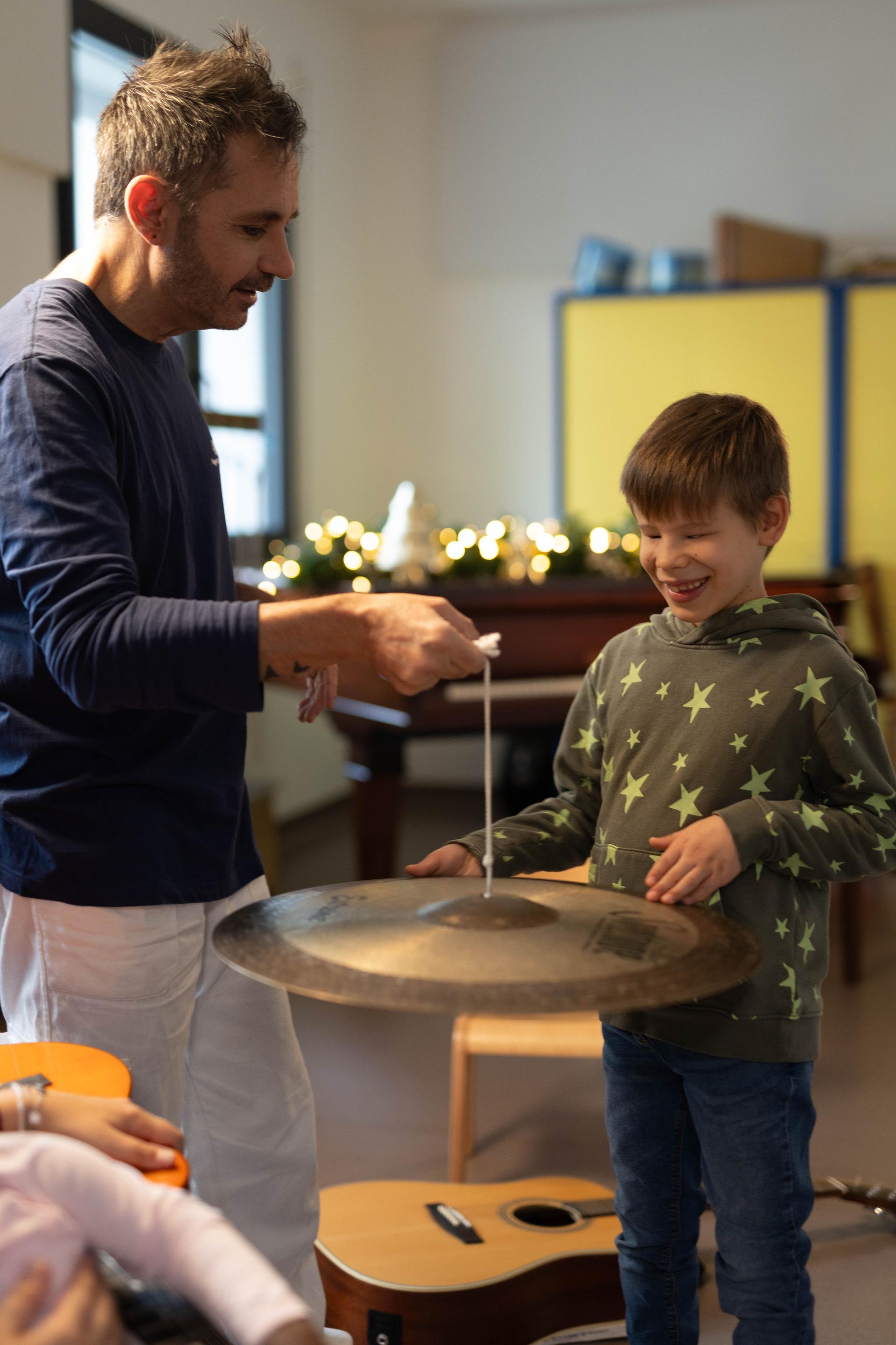 matteo, bambino che non vede, insiem al musicoterapista che tocca un rullante. 
