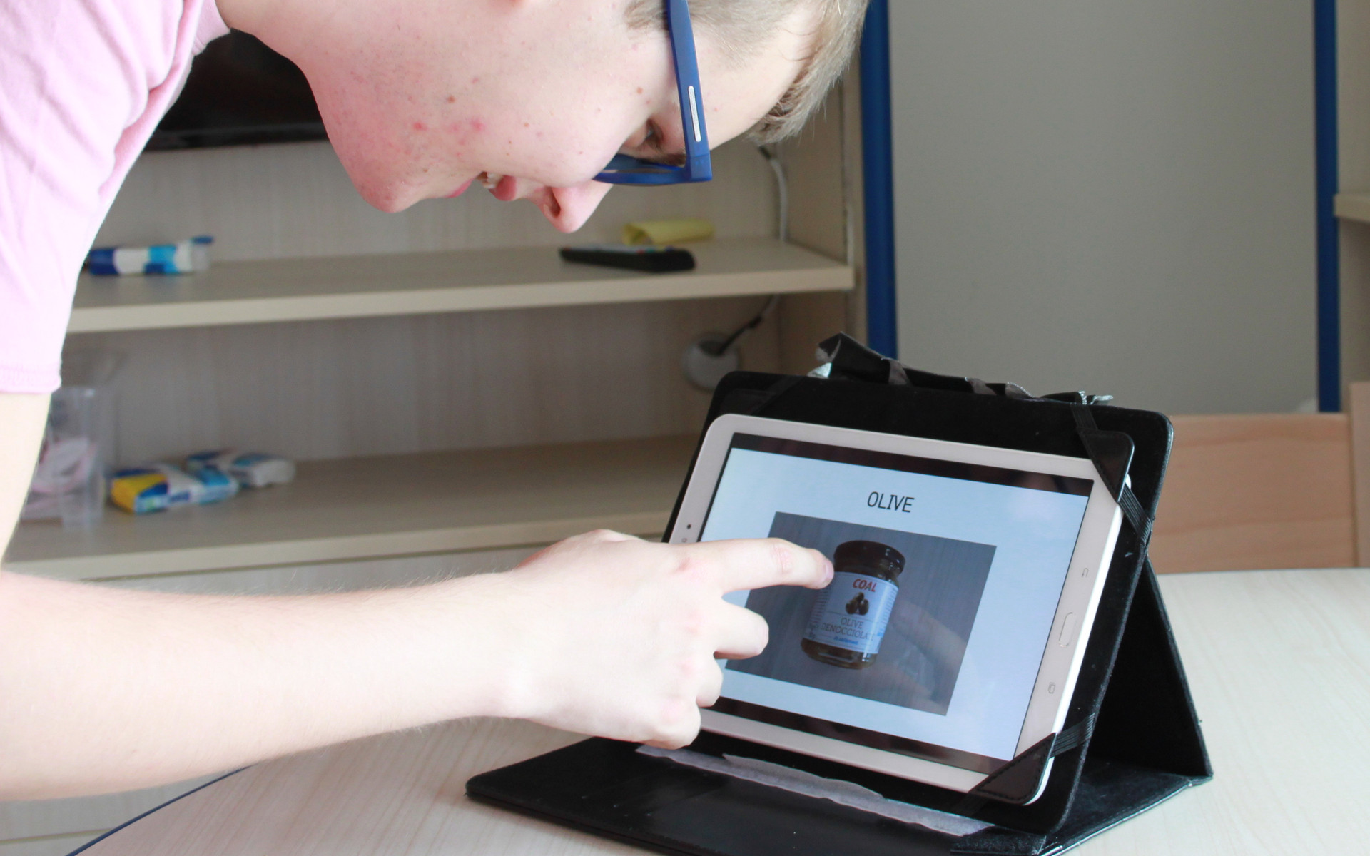 Victor, giovane utente del Centro di Osimo, fa riferimento a un tablet dove trova i diversi passaggi per la ricetta che sta preparando nella cucina del suo appartamento