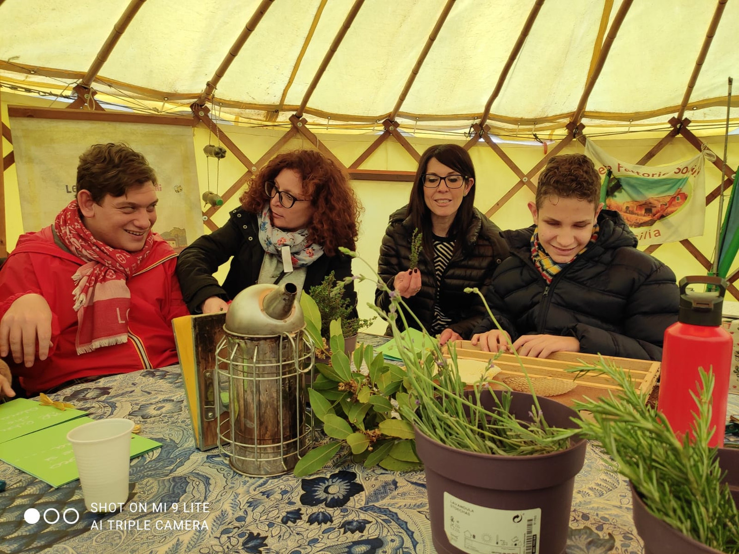 Flavio e Mirko, utenti della Lega del Filo d’Oro, sono impegnati in un’attività nell’orto insieme agli educatori e agli operatori. 