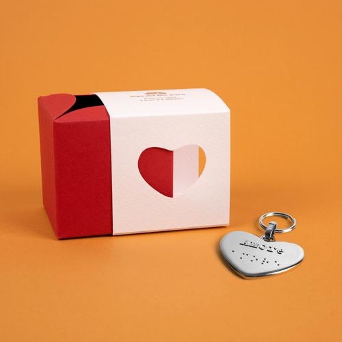 Bomboniera composta da due scatoline in cartoncino pregiato inserite l'una nell'altra. Quella esterna è bianca, quella interna, visibile da un'apertura a forma di cuore, è rossa. Accompagnata dal suo portachiavi cuore 42
