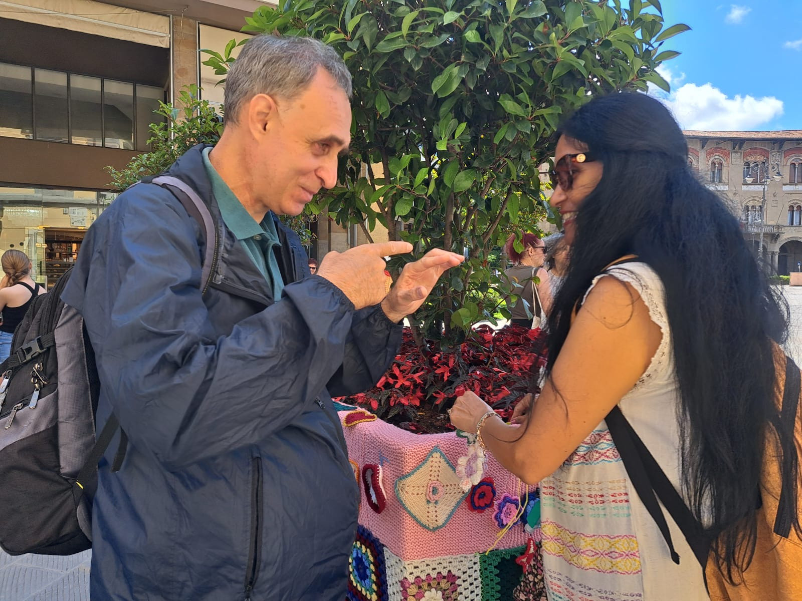 La Lega del Filo d’Oro ha aderito e promosso lo Yarn Bombing: a Pisa, un utente e una volontaria comunicano davanti all'angolo allestito con le creazioni in maglia