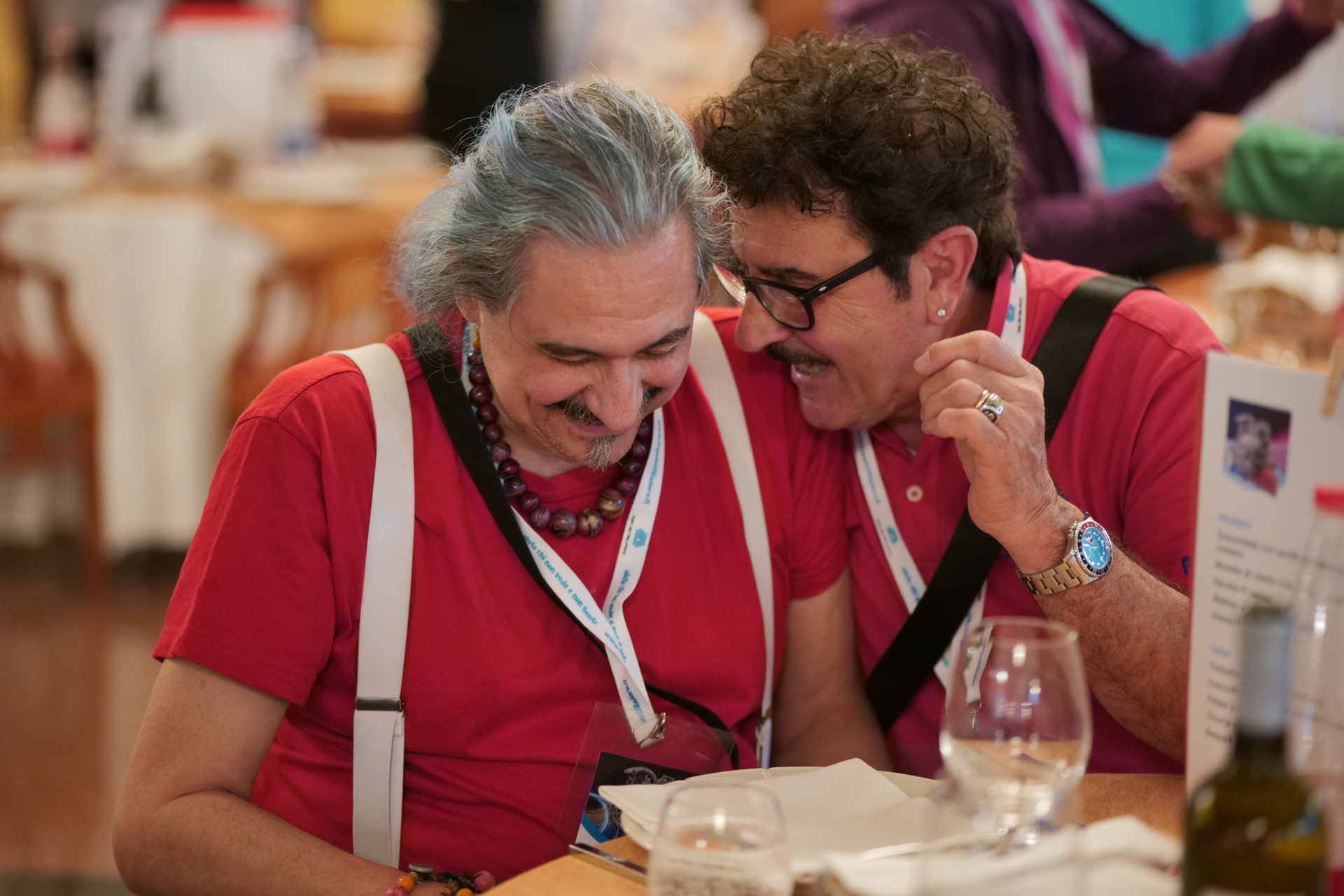 Roberto, mentre scherza con un volontario, alla Conferenza delle Persone Sordocieche organizzata dalla Lega del Filo d'Oro a Tivoli 2023. Al foto coglie un momento di complicità e affiatamento tra le due persone ritratte.
