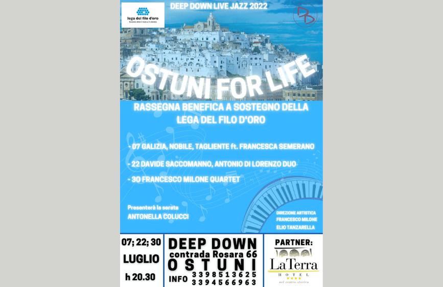 Locandina blu con in alto una foto panoramica di Ostuni e il titolo “Ostuni for Life” in bianco. Elenca concerti jazz benefici a luglio, con artisti e date. In basso, loghi della Lega del Filo d’Oro e dell’hotel partner “La Terra”.