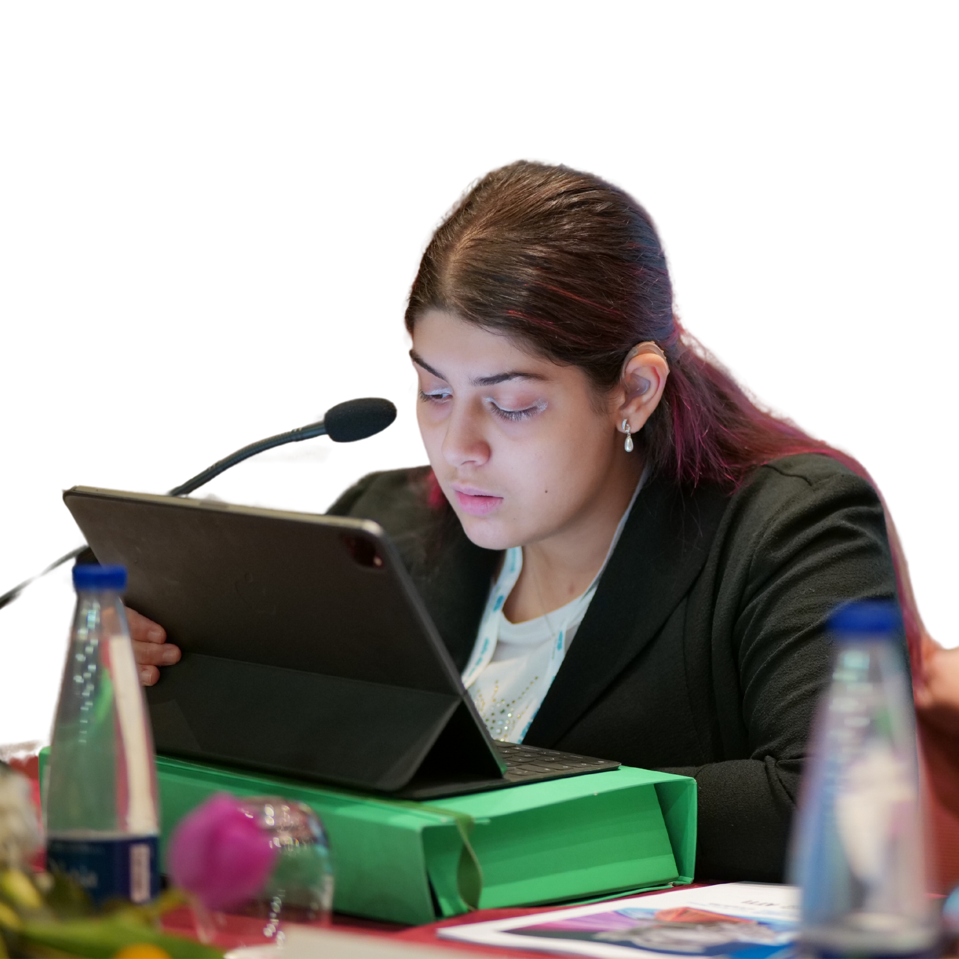 Lucia, giovane ragazza sordocieca seguita dalla Lega del Filo d'Oro, parla di fronte ad un microfono. Lo sfondo della foto è completamente nero.