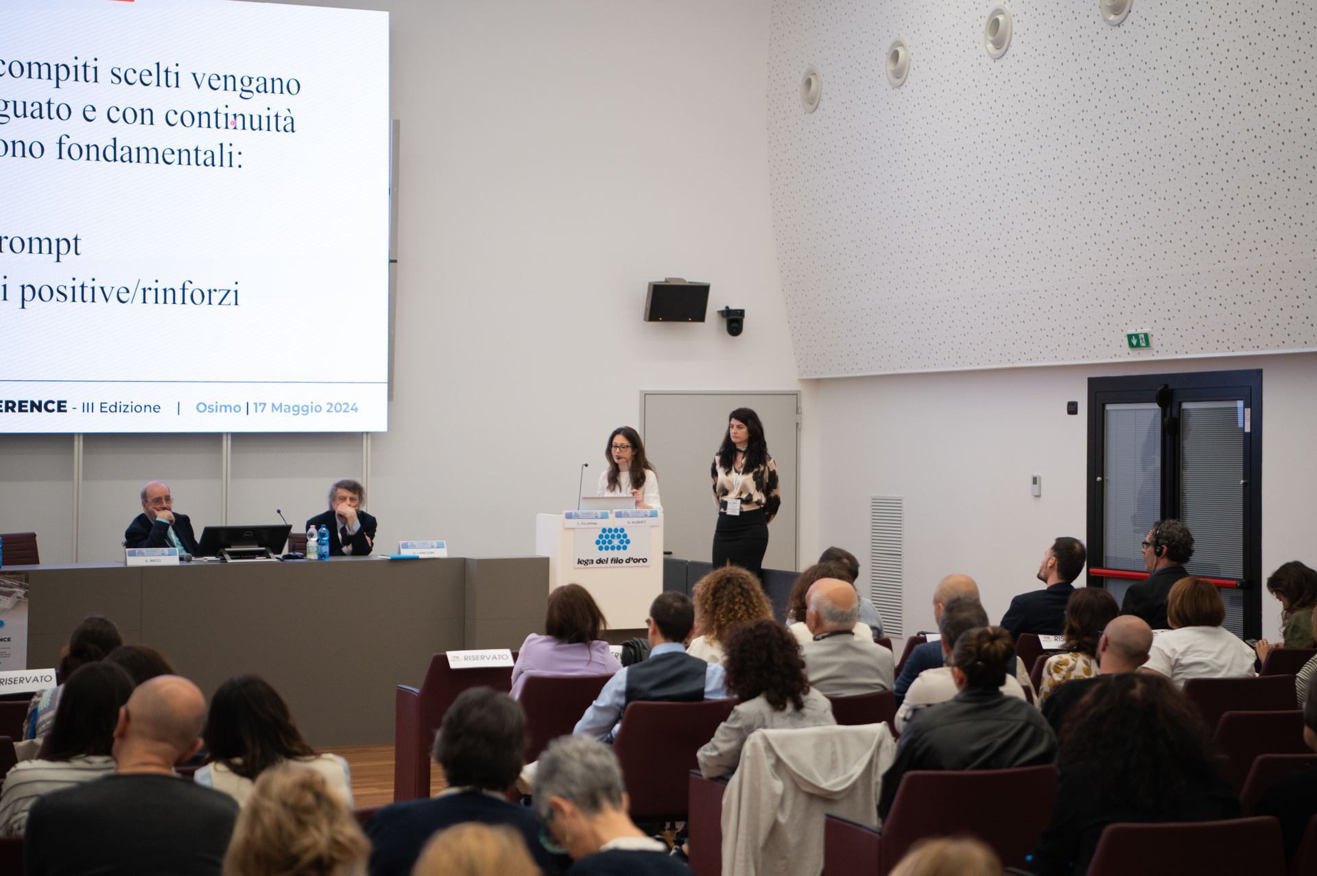 Terza Edizione della Conferenza Internazionale su Tecnologie Assistive e Disabilità. Relatrici parlano alla platea.