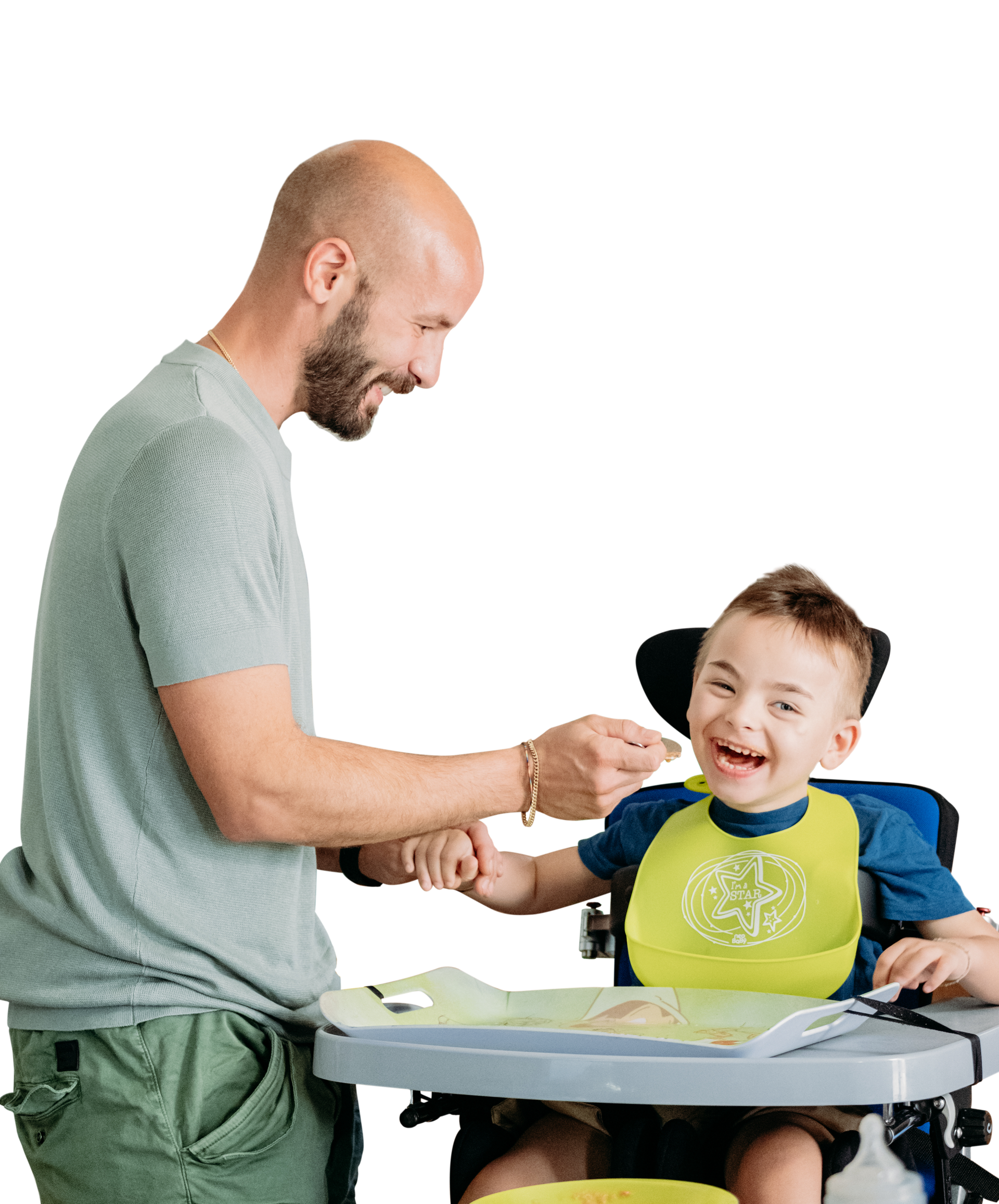 Edoardo e papà Giovanni insieme. Edo seduto sul seggiolone ride mentre papà Giovanni lo fa mangiare.