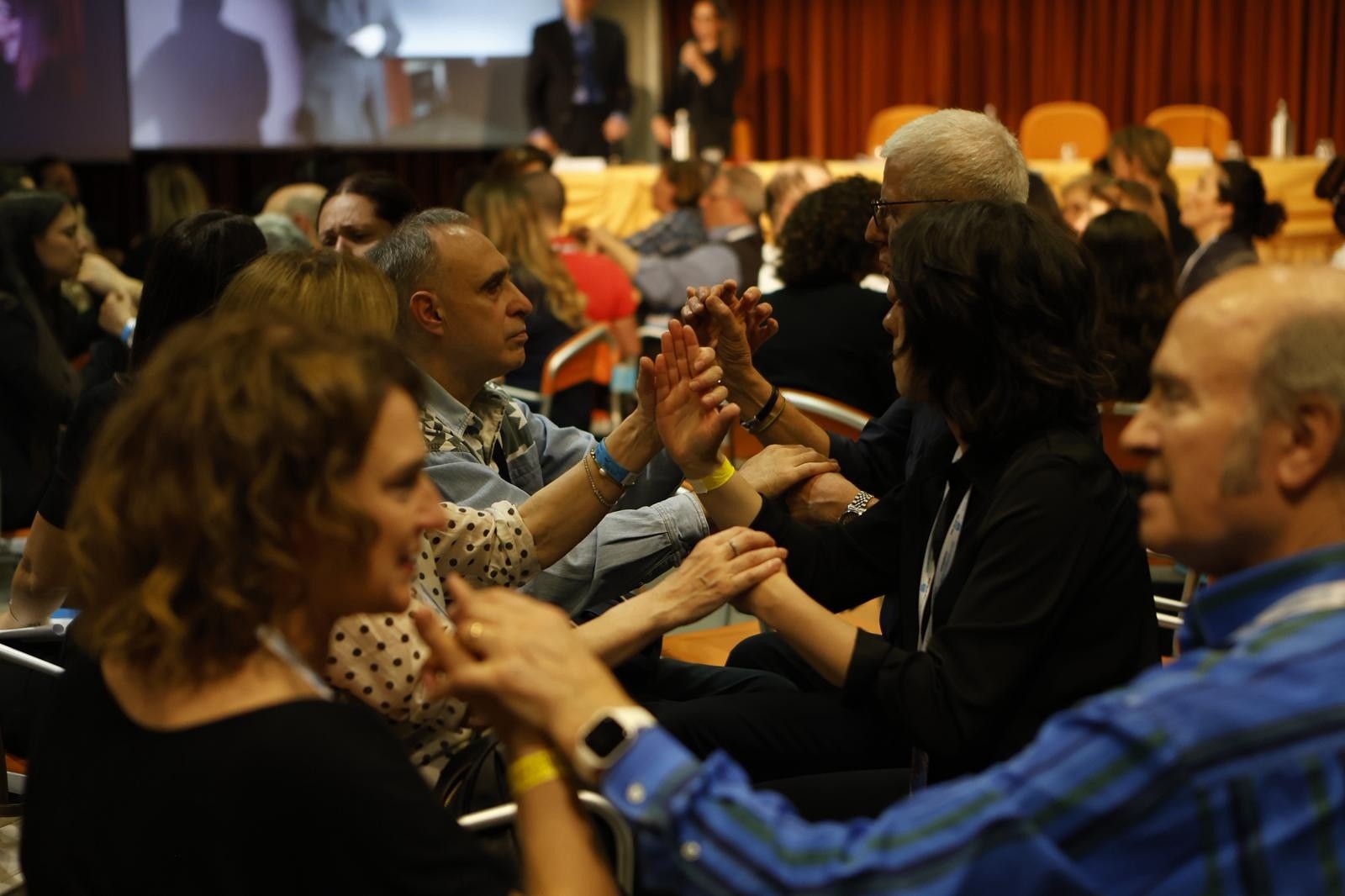 Persone con sordocecità che riescono ad essere partecipi - ascoltando e potendo fare domande - grazie alla vicinanza, uno ad uno, di interpreti di LIS Tattile 