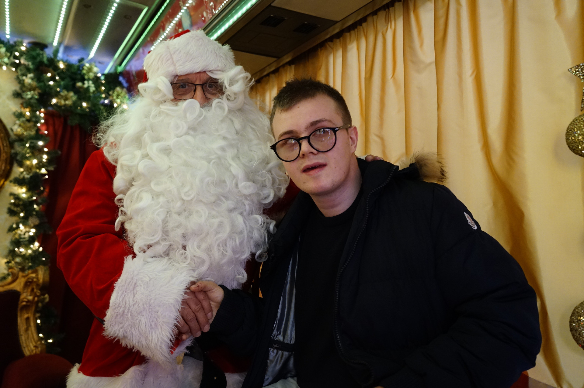 Adolescente della Lega del Filo d'Oro posa con Babbo Natale, creando un momento speciale e festoso. Perfetto per eventi natalizi e celebrazioni.