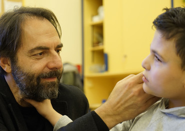 Neri Marcorè che accarezza il volto di un utente della Lega del Filo d'Oro