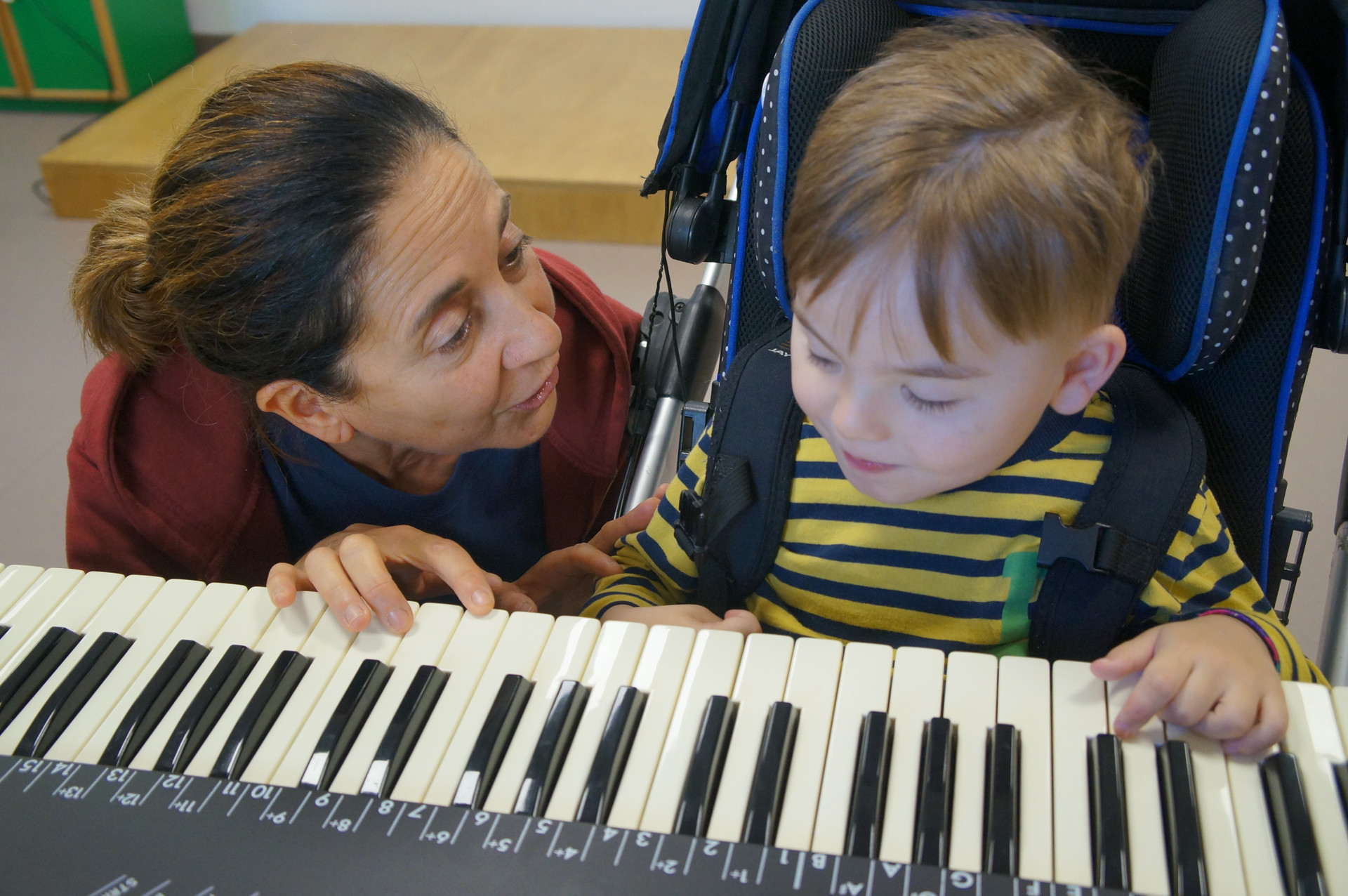 Fiammetta Musicoterapista del Centro di Osimo, insegna al piccolo Edoardo a suonare i tasti di un pianoforte