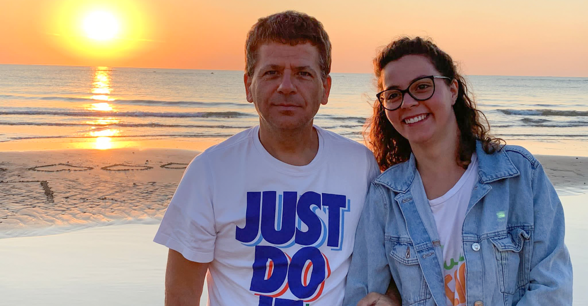 Letizia, volontaria alla Sede Territoriale di Padova, insieme ad un utente sono in posa per una foto al mare al tramonto.