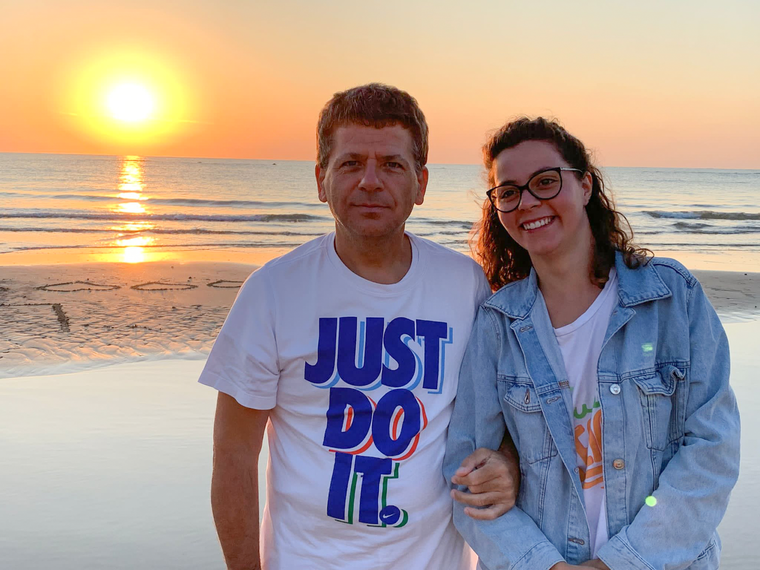 Letizia, volontaria alla Sede Territoriale di Padova, insieme ad un utente sono in posa per una foto al mare al tramonto.