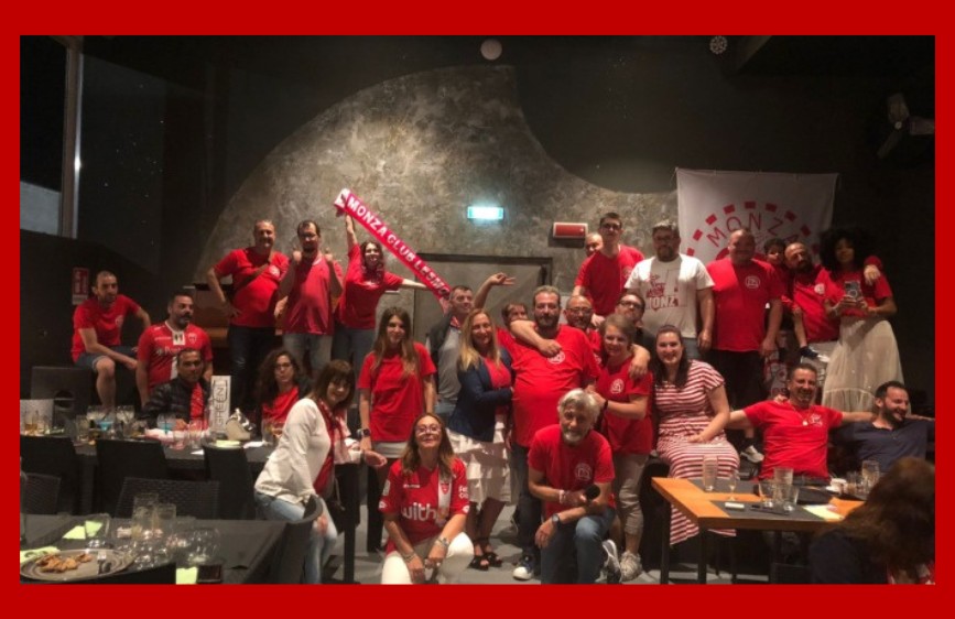 L' immagine ritrae un folto gruppo di tifosi del Monza Club, la maggior parte dei quali indossa magliette rosse, riuniti in un locale. Alcuni sono seduti a tavoli con bevande e stuzzichini, mentre altri sono in piedi, posando per la foto. Un uomo al centro solleva una sciarpa rossa con la scritta "MONZA CLUB", e sullo sfondo si intravede uno striscione bianco con il nome della squadra.