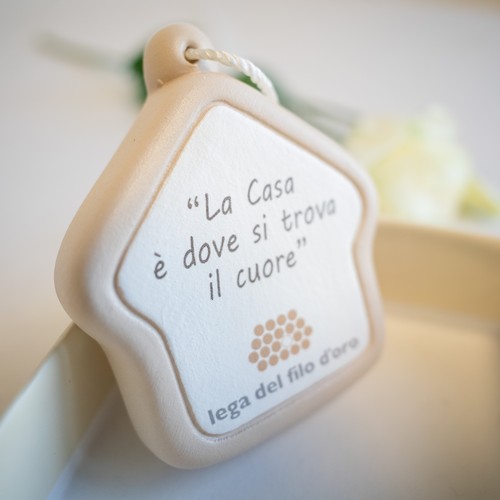 Scatto ravvicinato della Bomboniera composta da una casetta in ceramica appendibile, con la scritta "La casa è dove si trova il cuore" 59