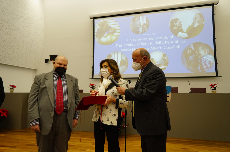 Il Presidente del Senato Elisabetta Casellati parla al microfono retto dal Presidente Rossano Bartoli. Accanto a lei si trova anche Francesco Mercurio, Presidente del Comitato delle Persone Sordocieche. 