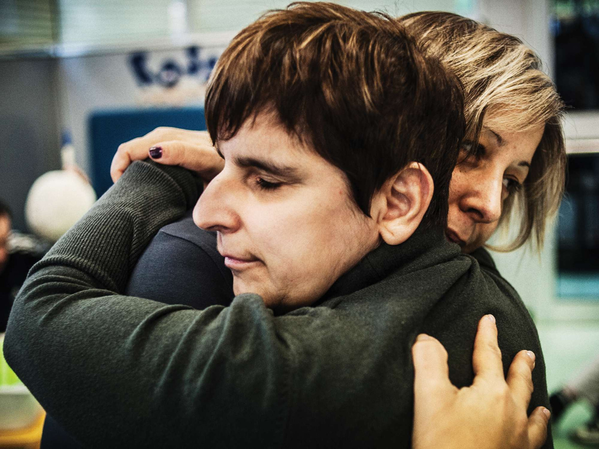Una donna e un'utente della Lega del Filo d'Oro si abbracciano.
