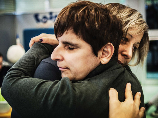 Una donna e un'utente della Lega del Filo d'Oro si abbracciano.