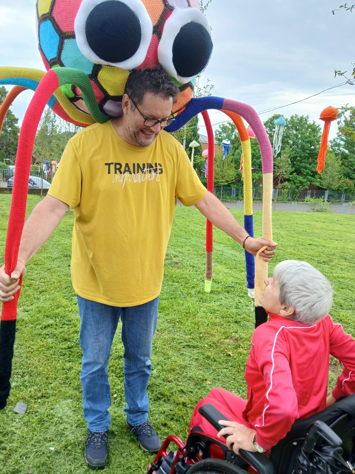 La Lega del Filo d’Oro ha aderito e promosso lo Yarn Bombing: ragni giganti fatti a maglia esposti in un parco. Un utente e un volontario toccano con mano queste sculture di maglia