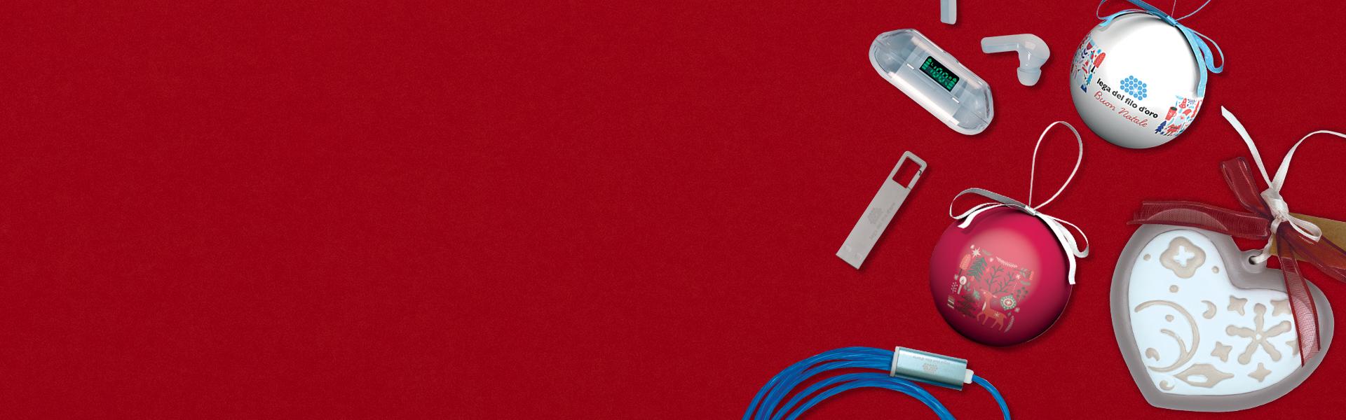 Composizione di prodotti dello shop su sfondo rosso, con in evidenza un cavo USB multicolore, una penna USB, auricolari wireless, una pallina natalizia e una ceramica a forma di cuore, perfetti per regali festivi e utili.