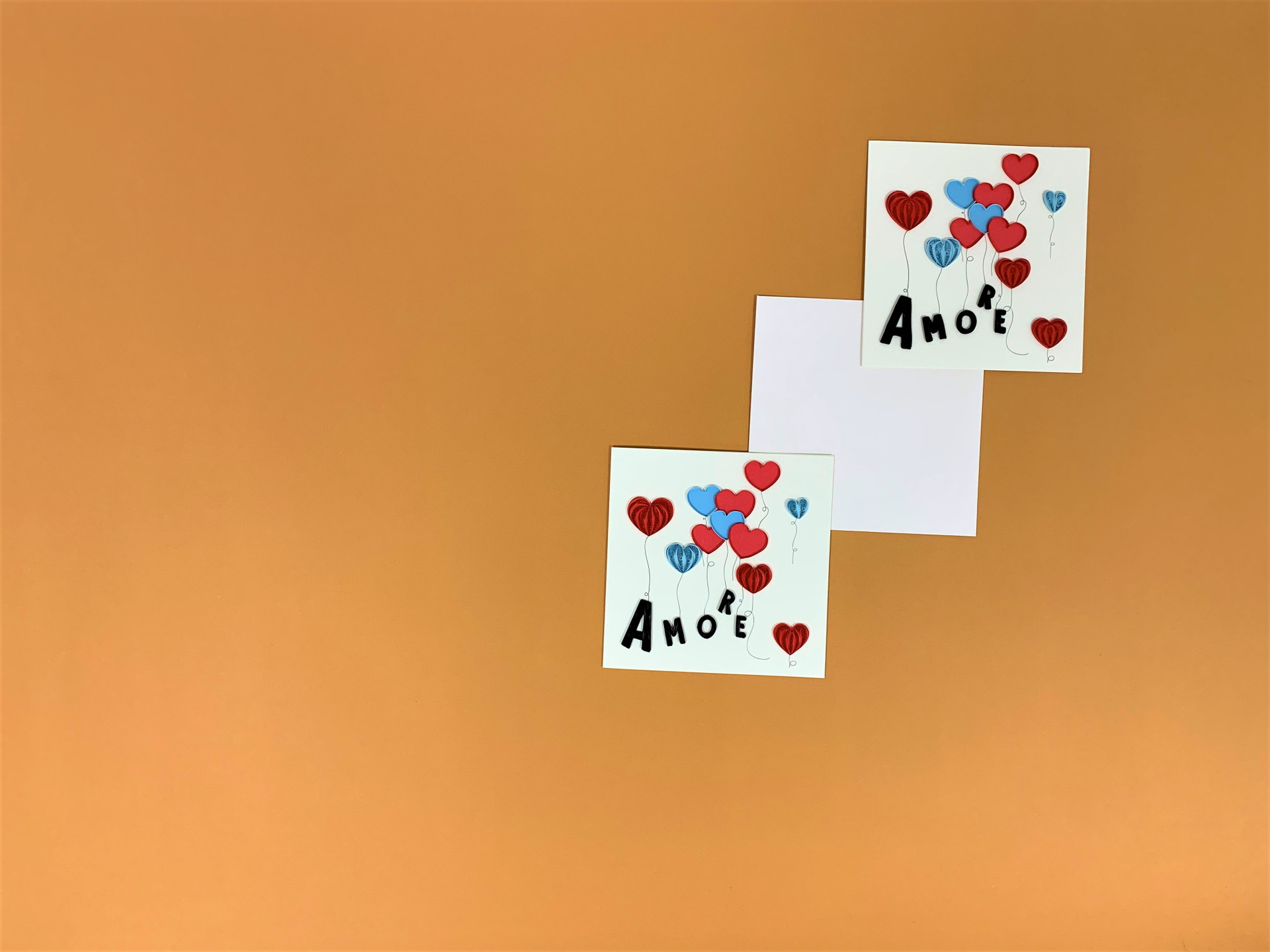 Composizione di due biglietti "Amore" su sfondo arancione.