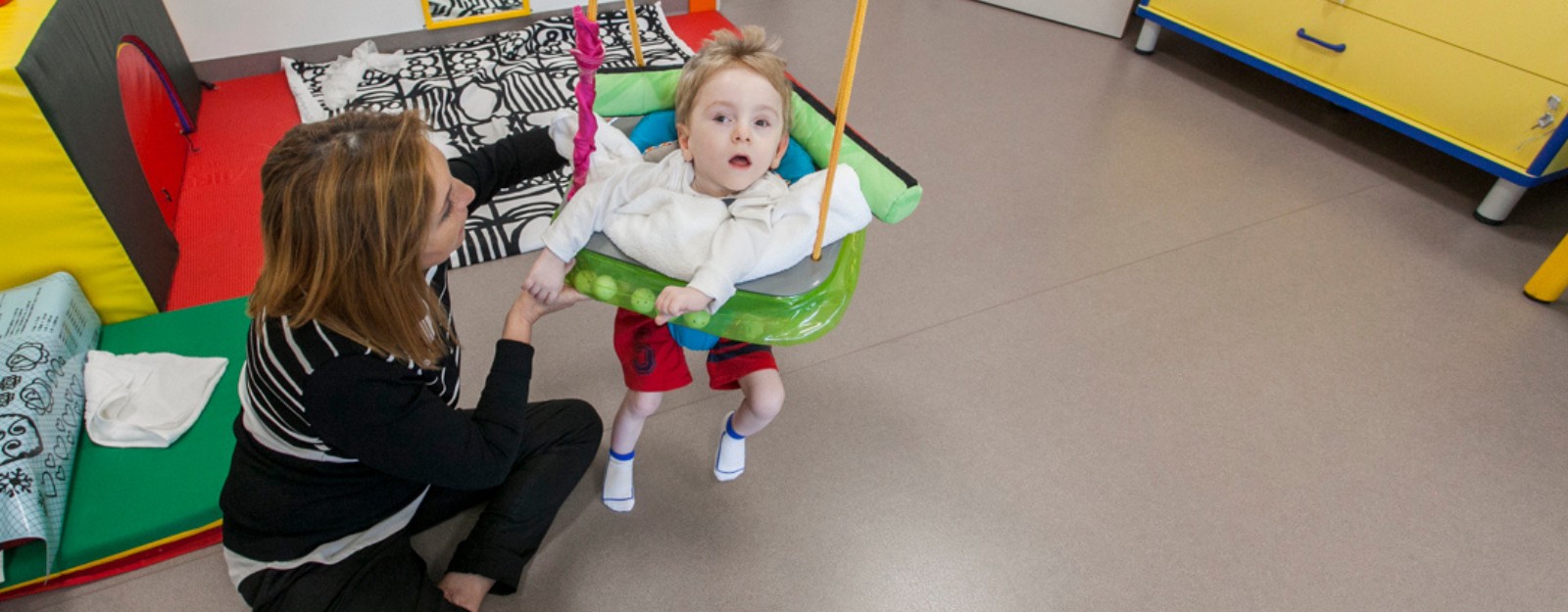 Foto di Gabriele piccolo utente della Lega del Filo d'Oro e Teresa operatrice mentre fanno attività al Centro Diagnostico 