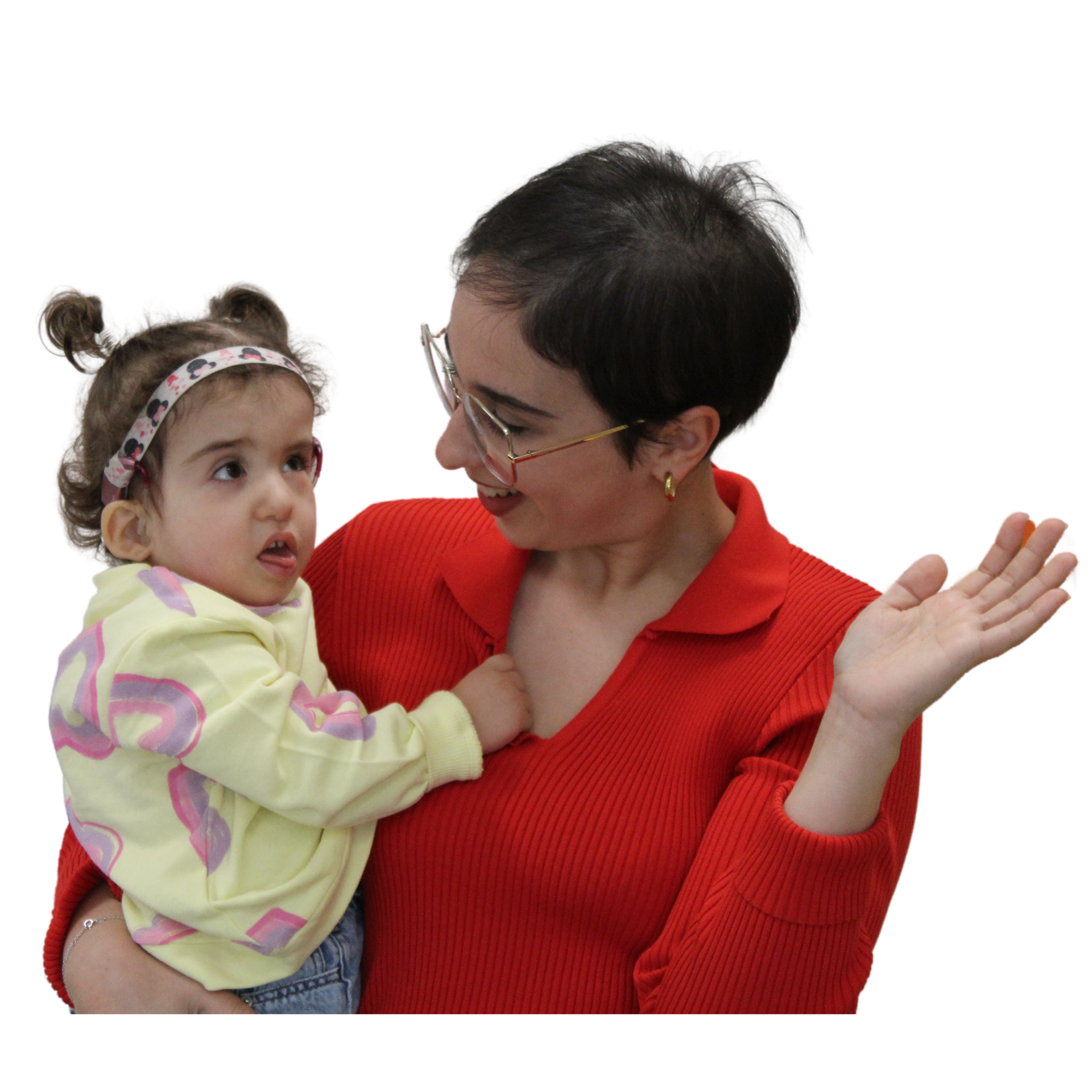 Primo piano di Sophie, bambina con sindrome in braccio alla mamma. Sophie ha circa 3 anni, indossa un maglionciono a fanatasia e una fascia per capelli. La mamma ha capelli neri, corti, indossa gli occhiali. Guarda Sophie e sorride