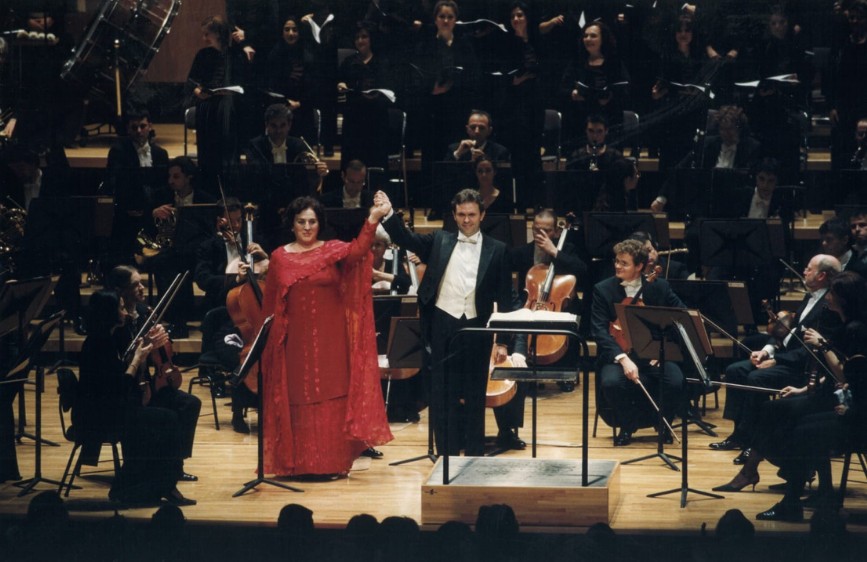 Immagine che rappresenta un complesso orchestrale con due persone in primo piano, un uomo e una donna