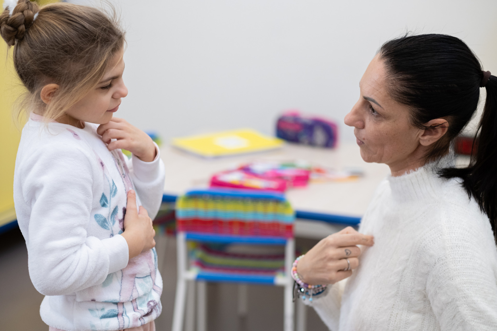 La bimba Sveva, utente della Lega del Filo d'oro, ritratta assieme alla sua mamma mentre comunicano attraverso la LIS